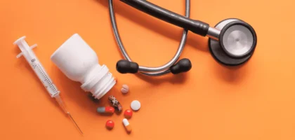 Assorted medication tablets and capsules in various colors on a white background.