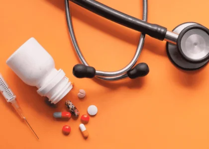 Assorted medication tablets and capsules in various colors on a white background.